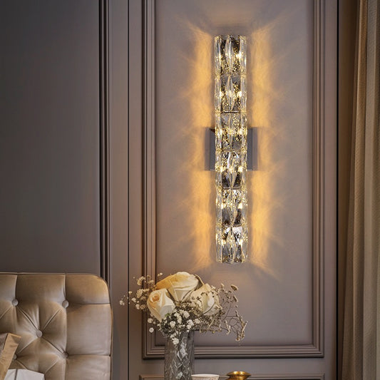 Decorative wall sconce with crystal design on a wall next to a sofa.